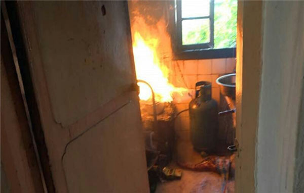 Spontaneous combustion of gas canisters in the Kunming residents and firemen hold a burning gas canisters rushed out of homes